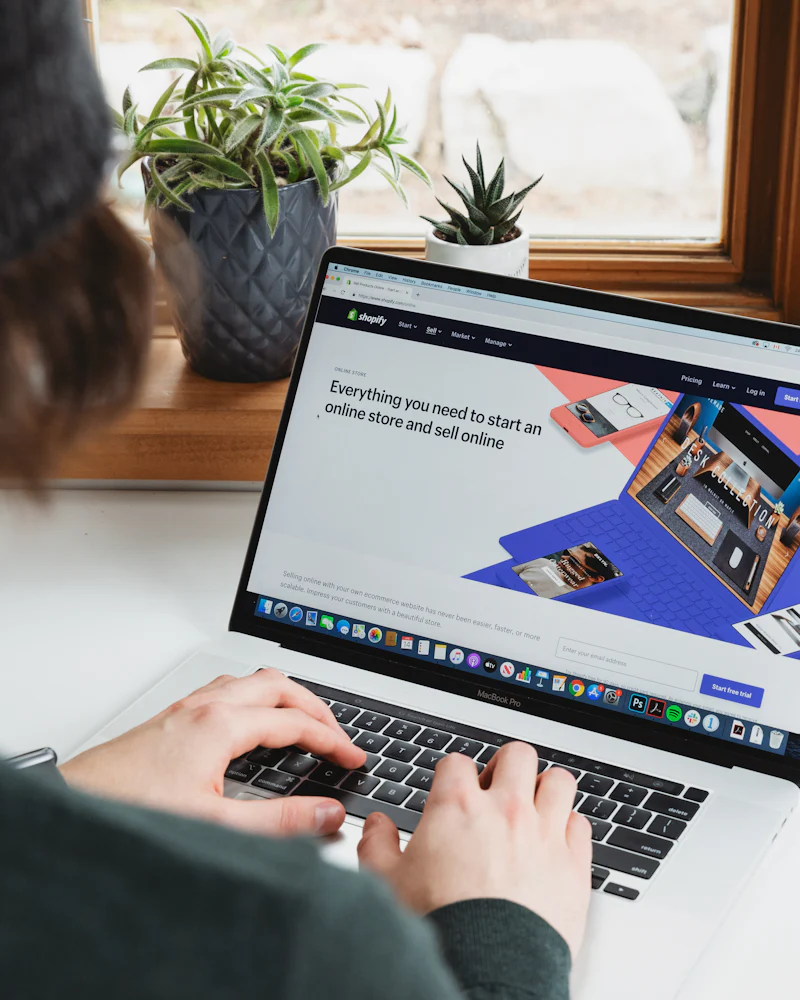 Eine Person arbeitet an einem Laptop auf einem hellen Tisch